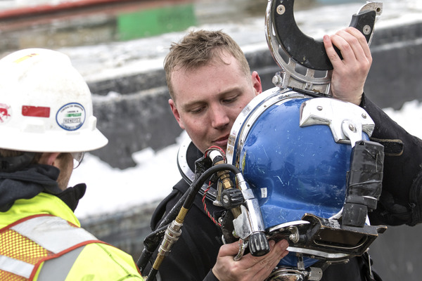 Accredited under ice diver reviewing equipment and helmet before dive