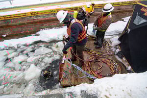 Two divers getting in water below the ice